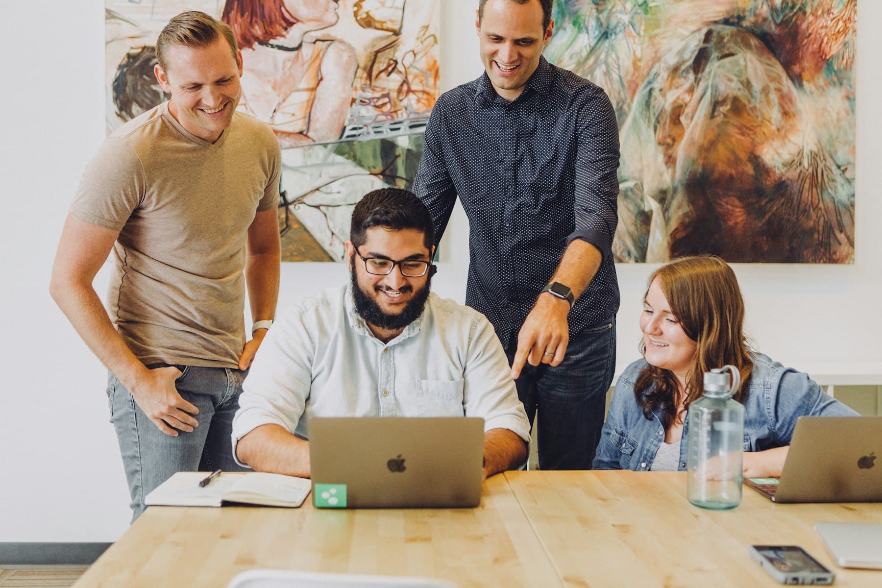A small team reviewing a project together around a laptop